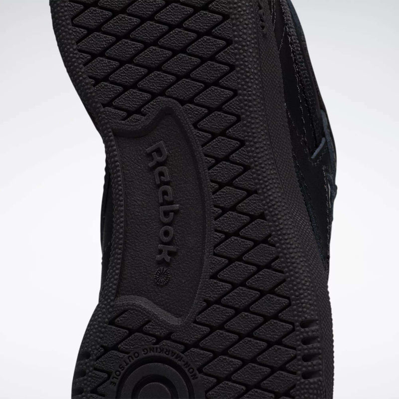 Close-up of the black rubber sole on Reebok Kids' Club C Shoes - Little Kids, featuring the Reebok logo and a textured tread pattern for grip—perfect for durable playground sneakers.