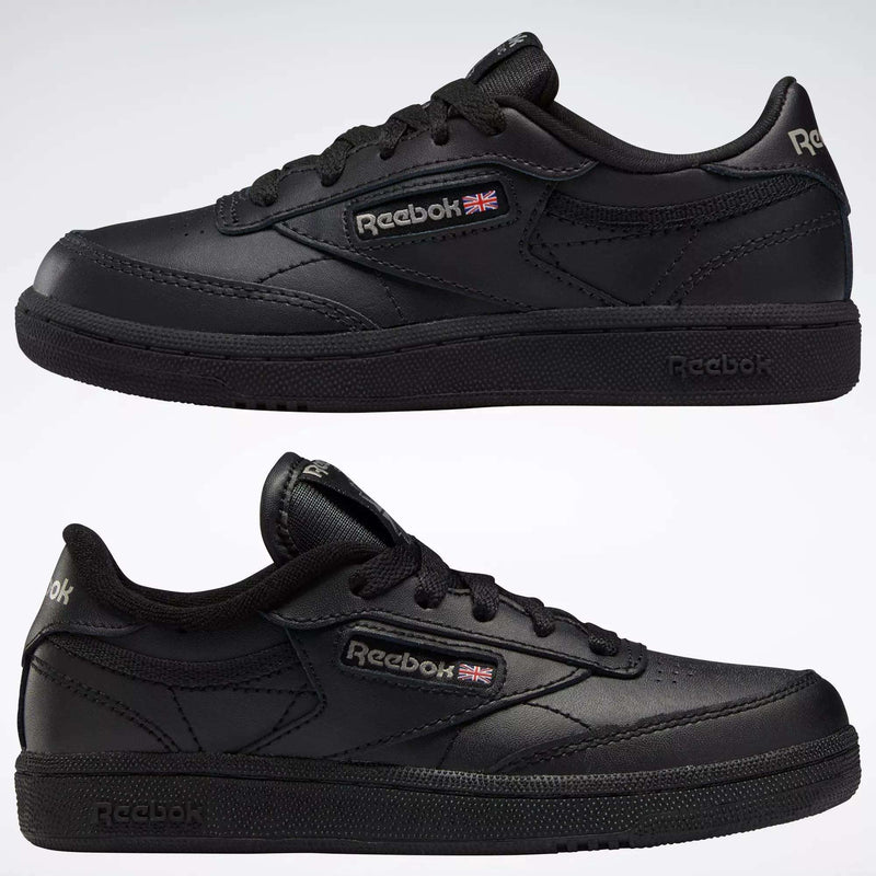 Two black Reebok Kids' Club C Shoes for little kids are shown from various angles on a white background, displaying leather uppers, the Reebok logo, and a small Union Jack flag—classic footwear built for durability.