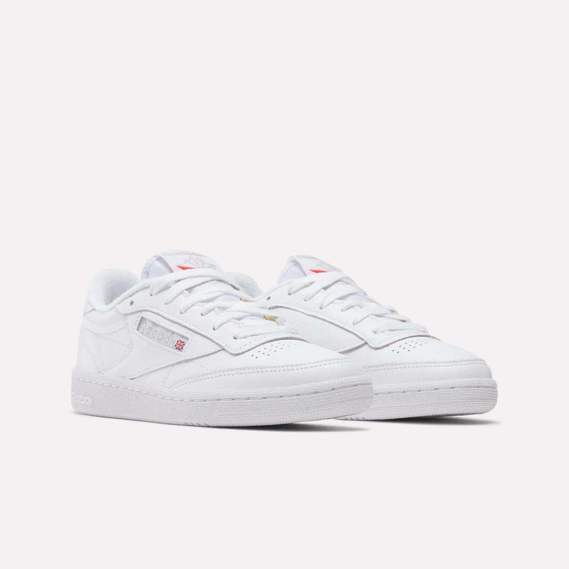 A pair of Reebok Women's Club C 85 Shoes with white laces and subtle grey and red branding is displayed against a plain white background.