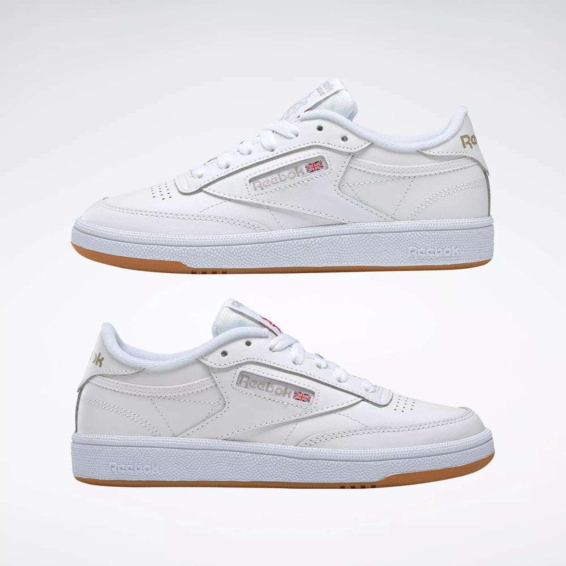 A pair of Reebok Women's Club C 85 Shoes in white with gum soles, side by side, showcasing the Reebok logo and UK flag—classic women's sneakers displayed against a plain white background.