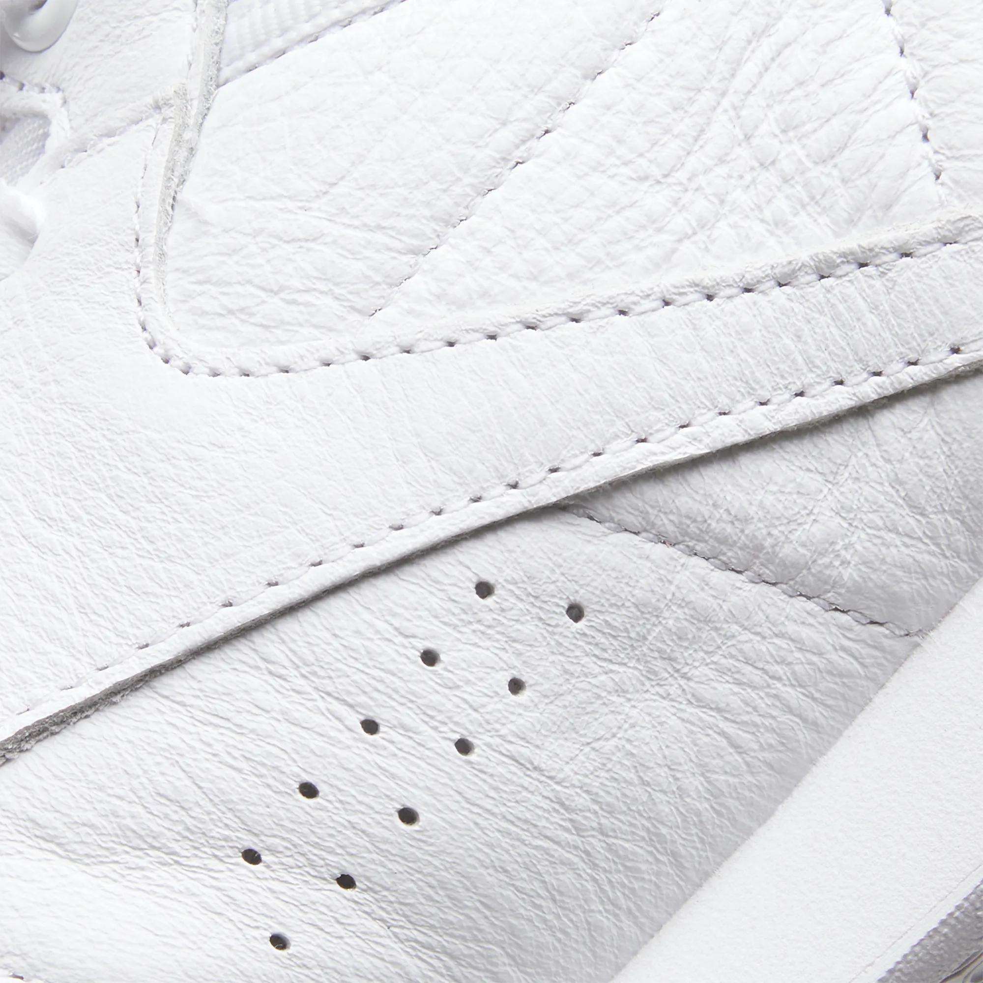 Close-up of Reebok Women's Freestyle Hi Shoes showcasing detailed stitching, textured leather surface, and perforated holes for ventilation—ideal for women's fitness routines.