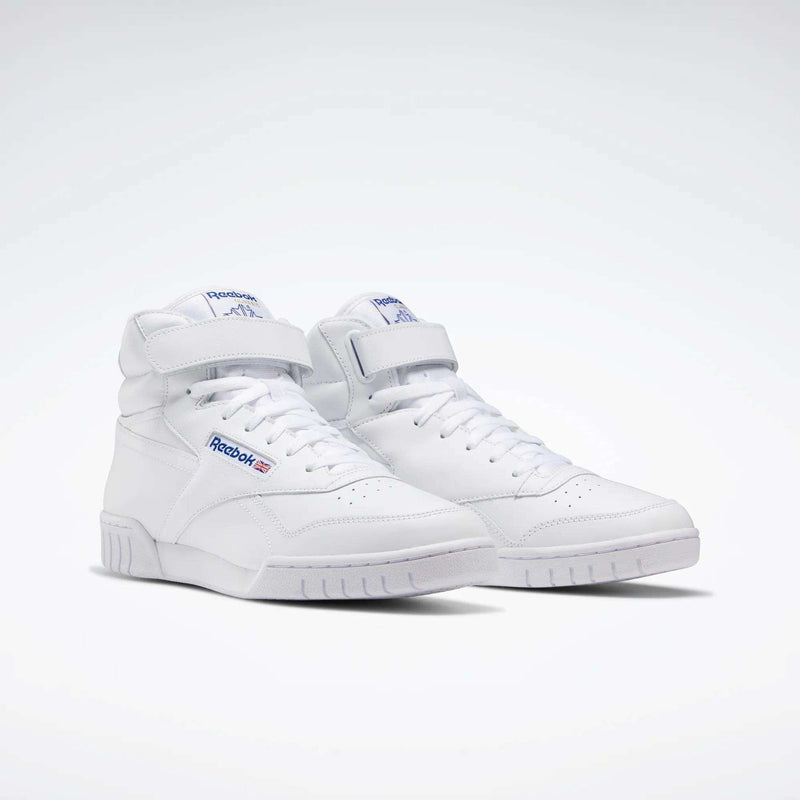 A pair of white Reebok Men's EX-O-FIT Hi Shoes features high-cut leather with Velcro straps and blue Reebok branding in a retro style, displayed on a light gray background.