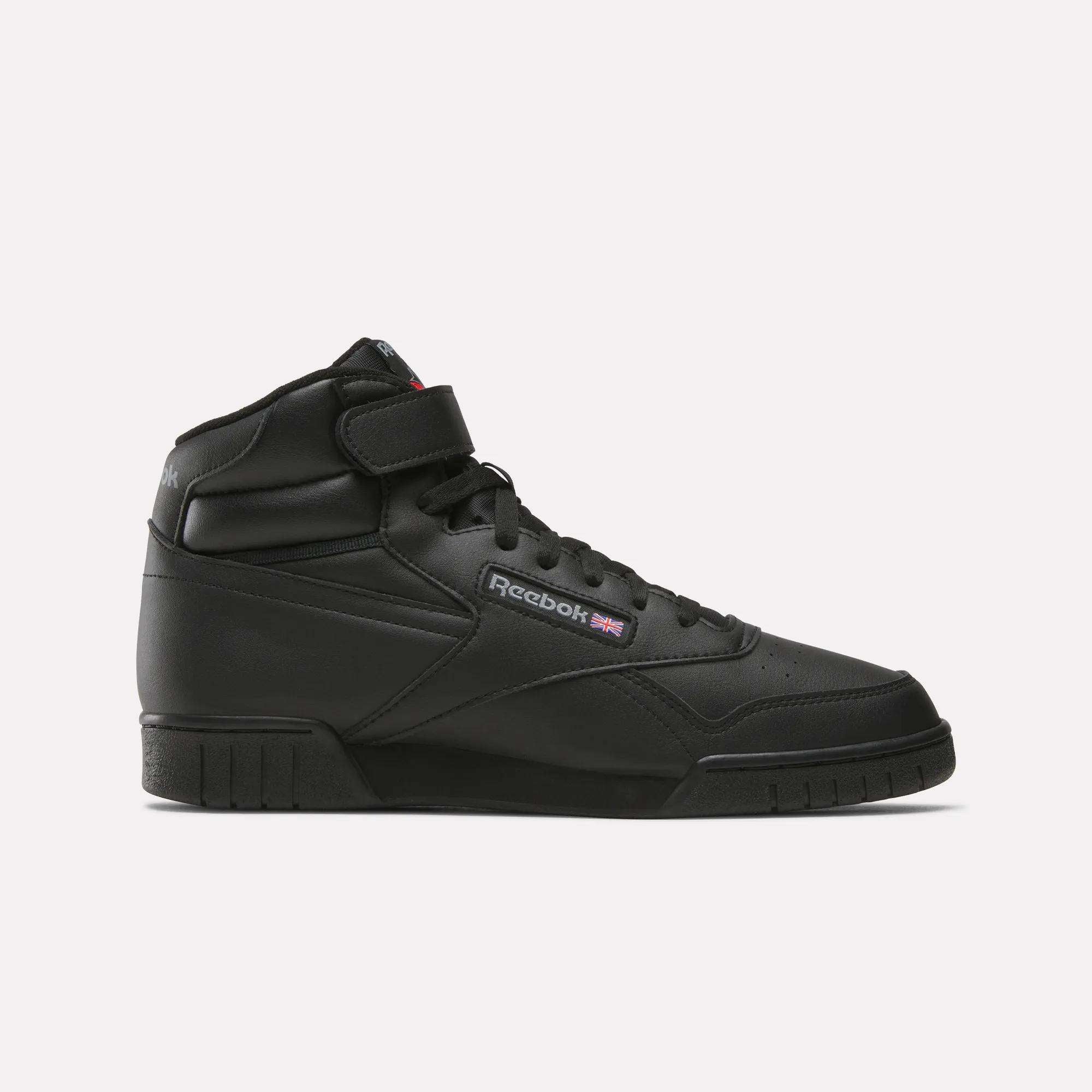 The Men's EX-O-FIT Hi Shoes by Reebok are black leather sneakers with a retro design, lace-up front, ankle strap, and side Reebok logo with Union Jack flag, shown against a plain white background.