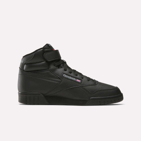The Reebok Men's EX-O-FIT Hi Shoes are black leather high-top sneakers with a velcro strap, laces, and retro design. They feature the Reebok logo and Union Jack flag on the side, shown against a plain white background.