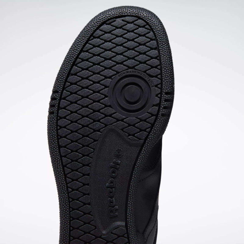 Close-up of the black rubber sole on the Reebok Club C 85 Shoes, featuring a textured hexagonal tread and circular groove, with visible Reebok branding—highlighting its tennis-inspired design.