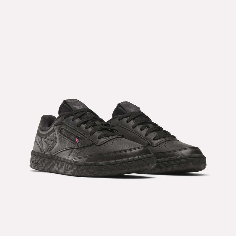 A pair of Reebok Club C 85 Shoes in black, featuring low tops, black laces, and subtle side and tongue branding, displayed on a plain white background.