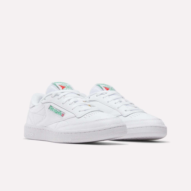 A pair of Reebok Club C 85 Shoes in classic white, featuring green and red logo details on the side and tongue, displayed against a plain white background.