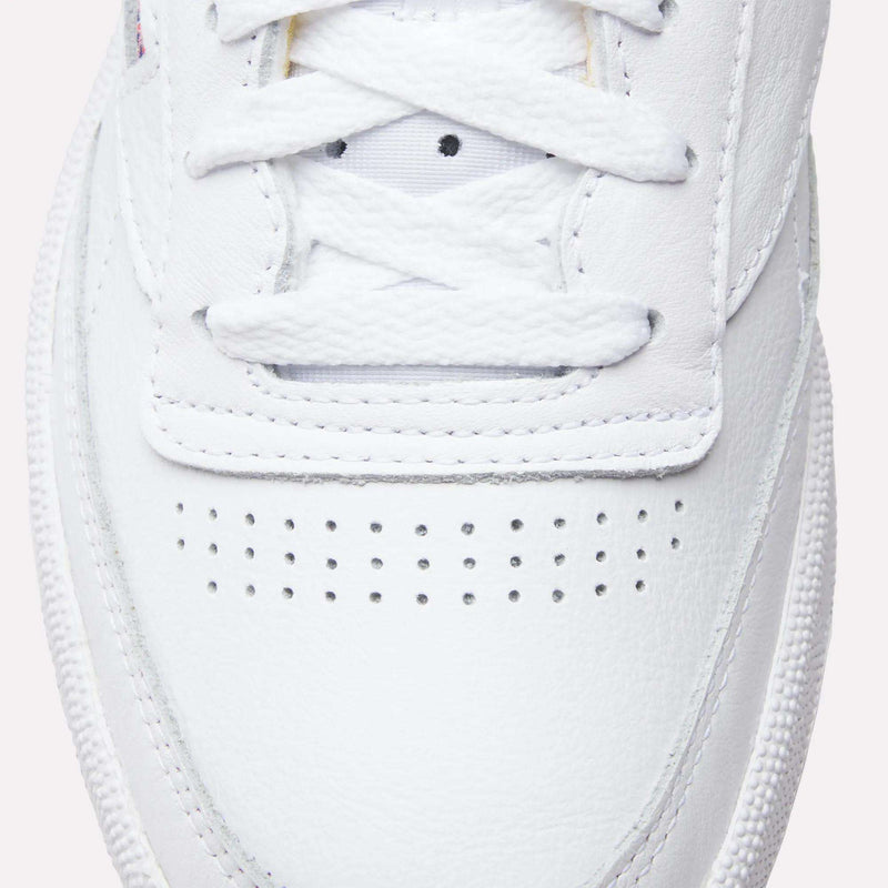 Close-up of the toe area on these Reebok Club C 85 Shoes, showing white laces, stitching accents, and small perforations on the leather upper.
