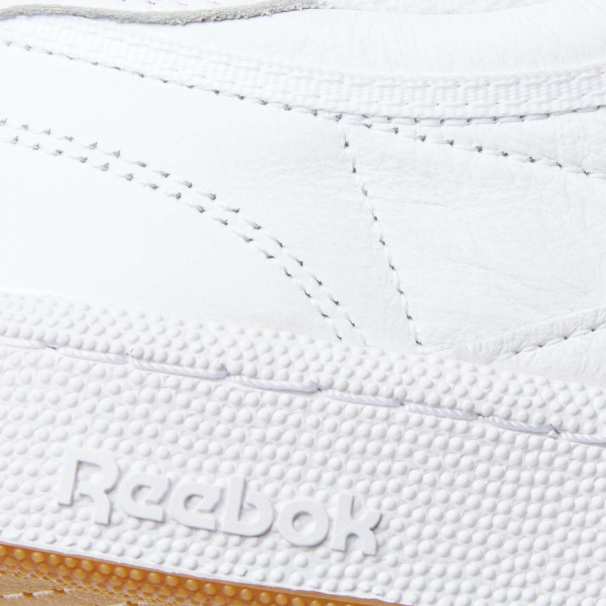 Close-up of the Reebok Club C 85 Shoes, showcasing detailed stitching on the white leather upper and the embossed Reebok logo on the textured rubber sole.