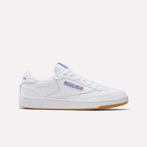 The Reebok Club C 85 Shoes feature a white leather upper, gum sole, blue Reebok branding, and a classic low-cut tennis-inspired design, shown on a plain white background.