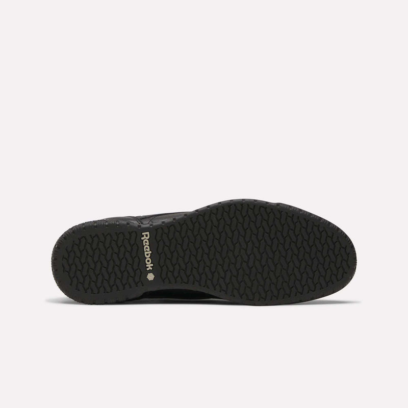 Men’s Exofit Lo Shoes by Reebok shown from the bottom, displaying a black low-profile design with a textured rubber sole and light Reebok branding near the heel on a plain, light background.