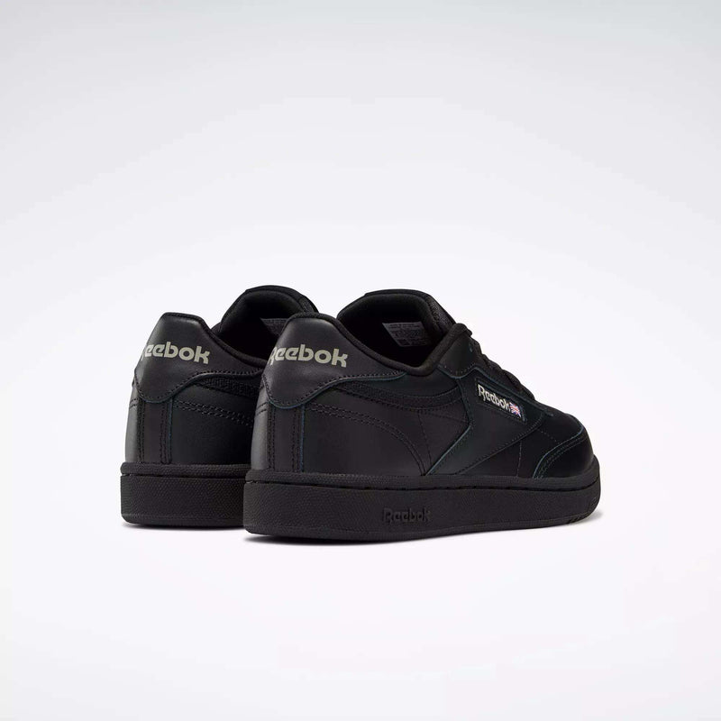 A pair of Reebok Kids' Club C Shoes - Grade School in black, featuring subtle logo details and soft leather uppers, displayed from an angled rear view on a plain white background.