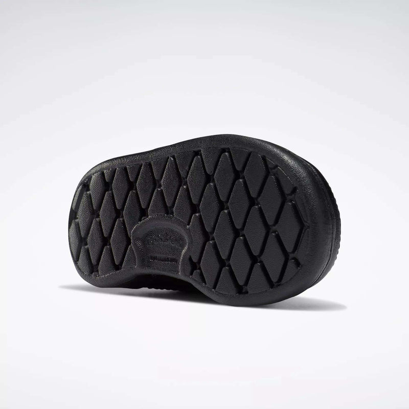 Black rubber sole with diamond-shaped tread, viewed from below on a white background. Made for Reebok Kids' Club C Shoes - Baby & Toddler, it features a rounded shape and subtle branding near the arch.