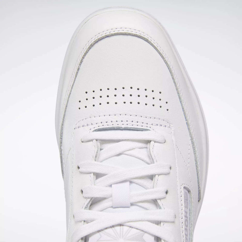 Close-up of the Reebok Women's Club C Double Shoes featuring a white tennis-inspired design, smooth leather upper, toe box, white laces, perforated holes for ventilation, and detailed stitching.