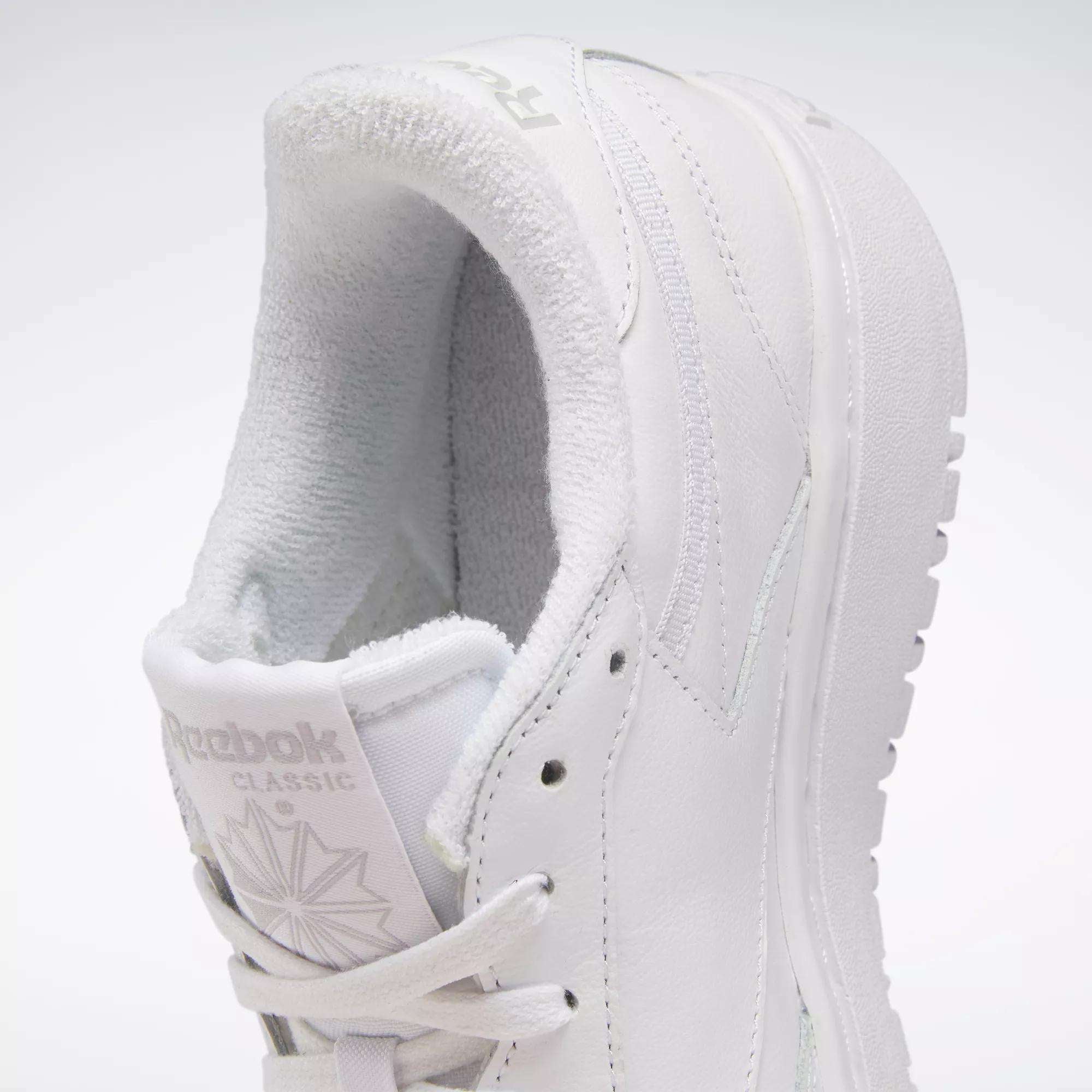 A close-up side view of the Women's Club C Double Shoes by Reebok, showcasing their tennis-inspired design with detailed laces, tongue, stitching, platform midsole, and Reebok branding on the tongue and heel.
