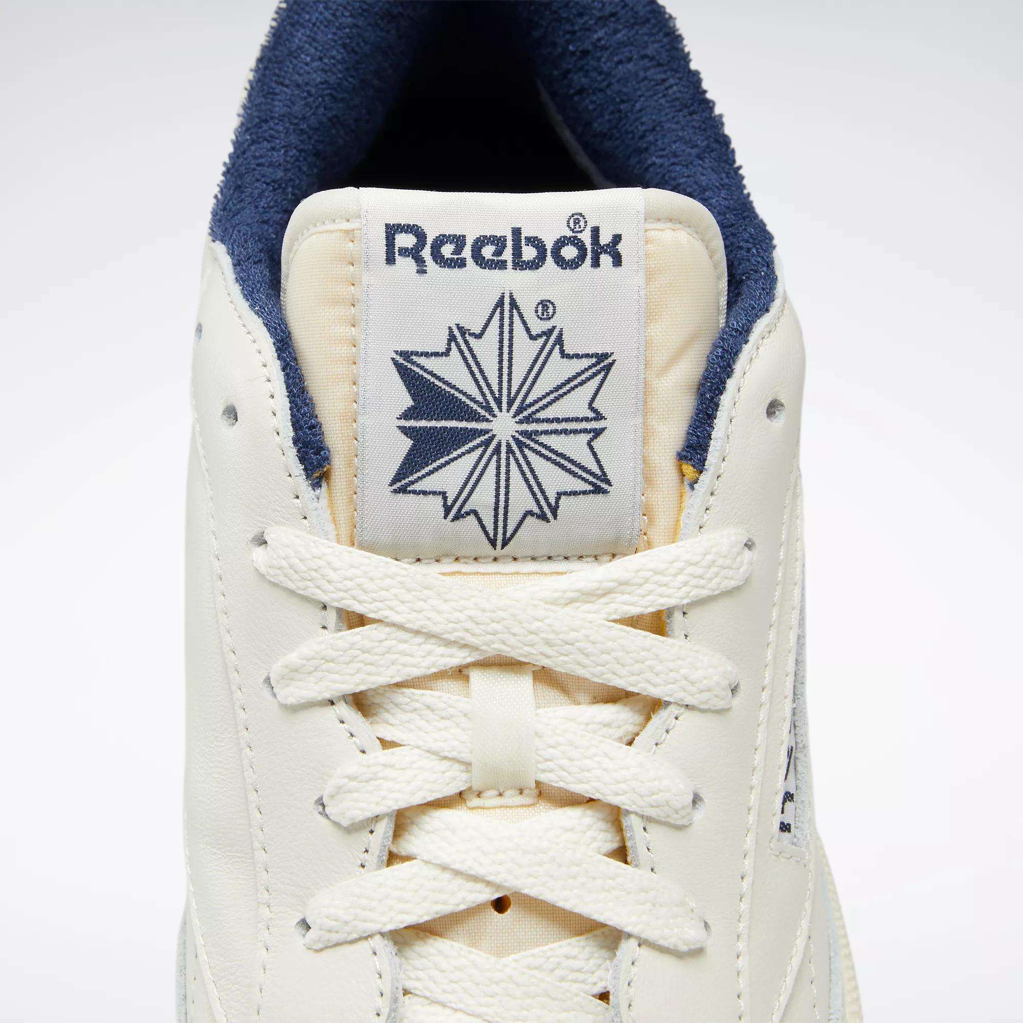 Close-up of the Reebok Club C 85 Vintage Shoes featuring a cream-colored leather upper, white laces, signature Reebok logo, star design on the tongue, and dark blue inner lining for lightweight cushioning and all-day comfort.
