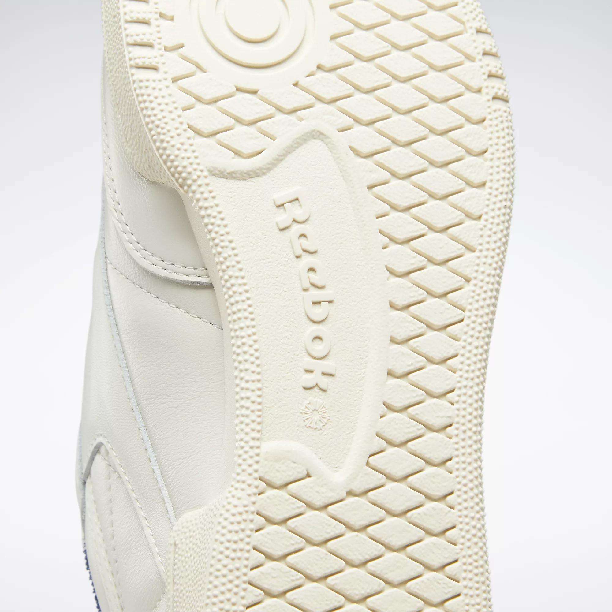 Close-up of the off-white rubber sole on Reebok’s Club C 85 Vintage Shoes, highlighting the textured tread pattern and embossed Reebok logo at the center.