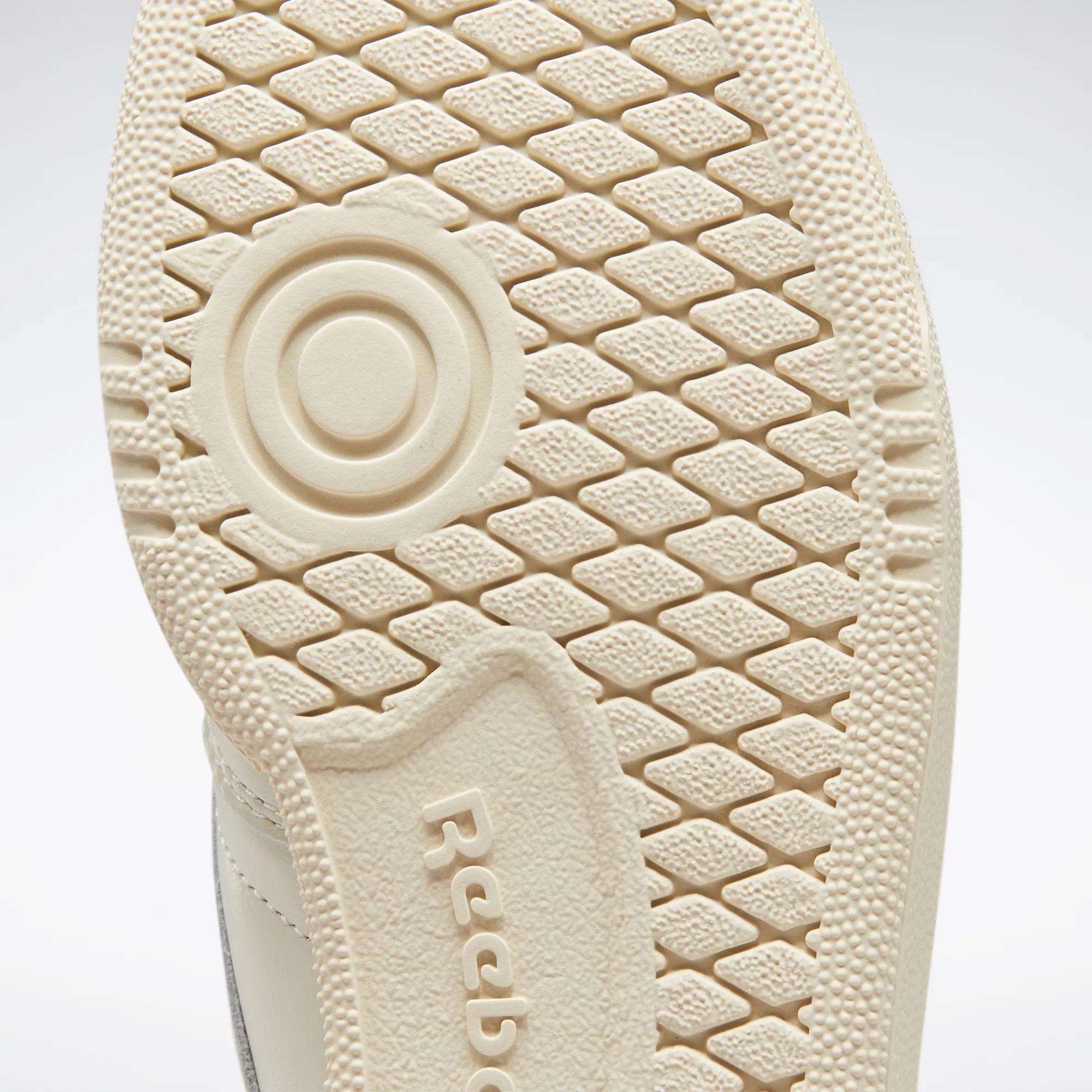 Close-up of the textured beige sole of a Reebok Women's Club C 85 Vintage Shoe, showing a circular pattern and the embossed Reebok logo.