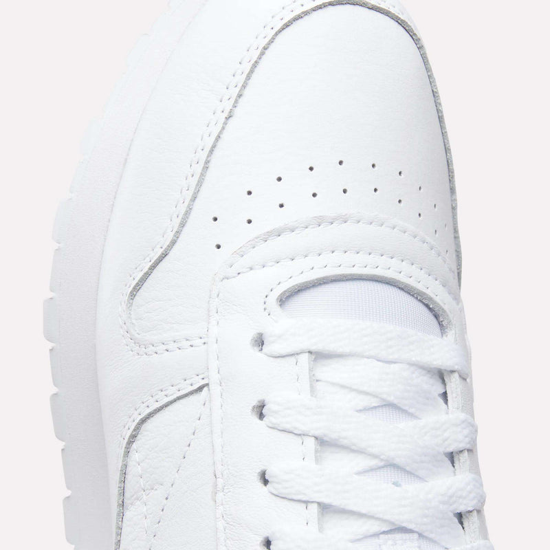 Close-up of the toe and laces on Reebok Classic Leather Shoes, showing detailed stitching, breathable perforations, and a textured rubber sole in these retro-inspired sneakers.