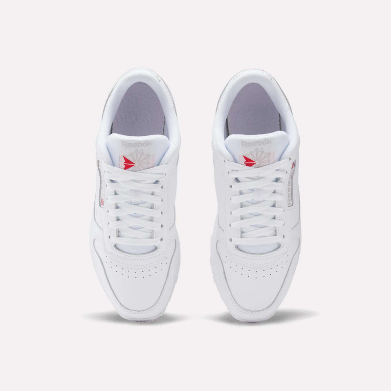 A top view of Reebok Classic Leather Shoes shows a leather upper with laces, perforated toes, and red Reebok logos on the tongues, offering a timeless retro style.