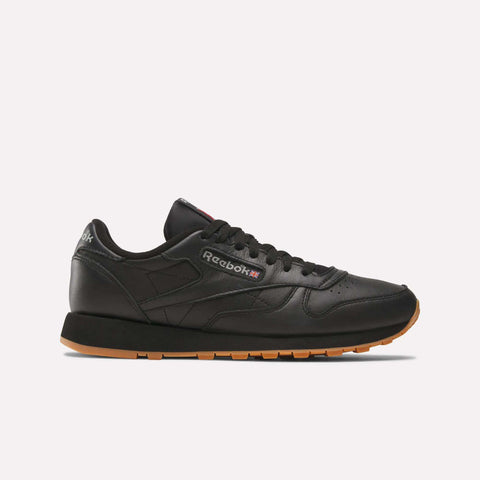 The Reebok Classic Leather Shoes in black feature a gum sole, black laces, and side Reebok branding—shown on a plain white background—ideal for those who appreciate timeless retro footwear.