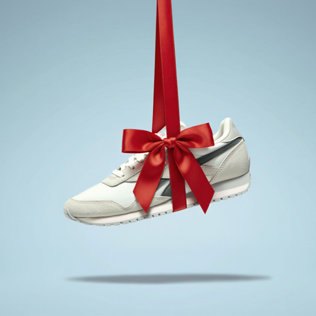 White sneaker with a red ribbon on a light blue background