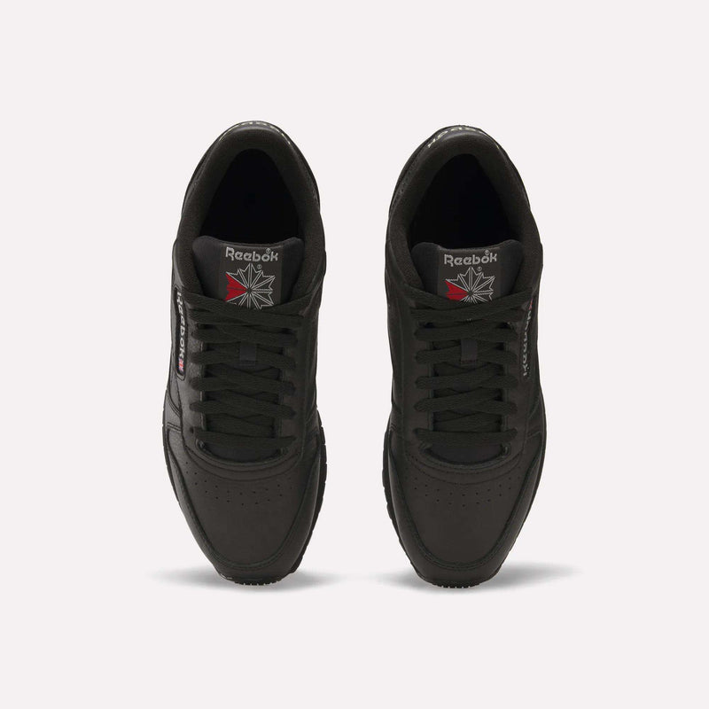 Top view of a pair of black Reebok Classic Leather Shoes featuring durable leather uppers, perforated toe caps, and Reebok branding with UK flag details on the tongues and side labels, displayed on a plain white background.