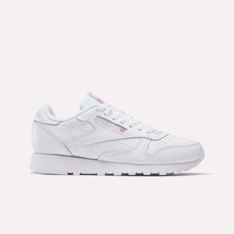 The Women's Classic Leather Shoes by Reebok feature a low-top design, cushioned midsole, white laces, and subtle side and tongue branding, shown against a plain light background.