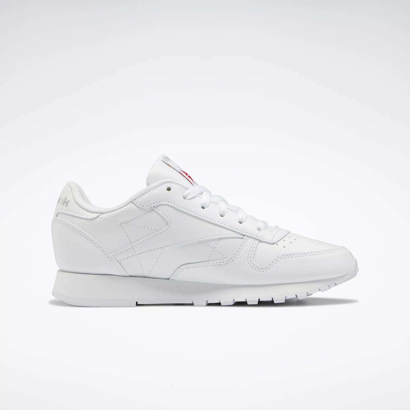 Reebok Women's Classic Leather Shoes feature a low-top design, cushioned midsole, lace-up closure, and subtle side and tongue branding, showcased against a plain white background.