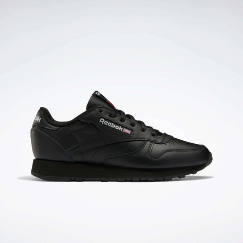The Reebok Women's Classic Leather Shoes feature a black low-cut design, cushioned midsole, black sole, and side Reebok logo with Union Jack, shown against a plain white background.
