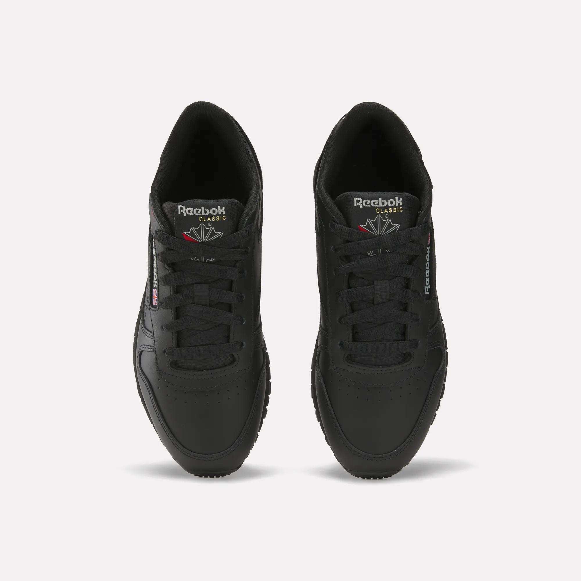 A pair of Women's Classic Leather Shoes by Reebok in black, shown from above with visible tops, laces, and the Reebok logo on the tongue and side—stylish footwear ideal for any casual outfit.