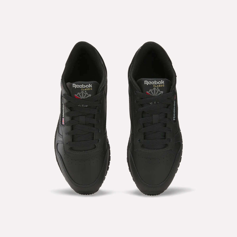 A pair of Reebok Women's Classic Leather Shoes in black, seen from above with visible laces, the Reebok logo on the tongue, side branding, and a cushioned midsole, all displayed on a plain white background.
