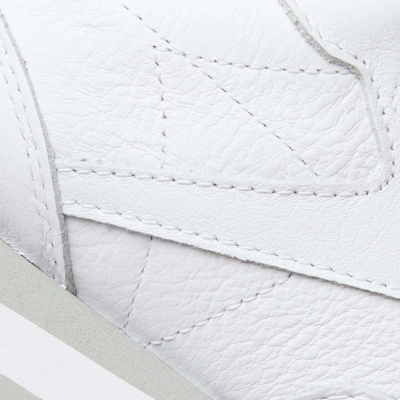 Close-up of Reebok Classic Leather Shoes in white, featuring detailed textured leather, visible stitching, and layered panels. The geometric stitching reflects the timeless retro style of the iconic Reebok Classic Leather.