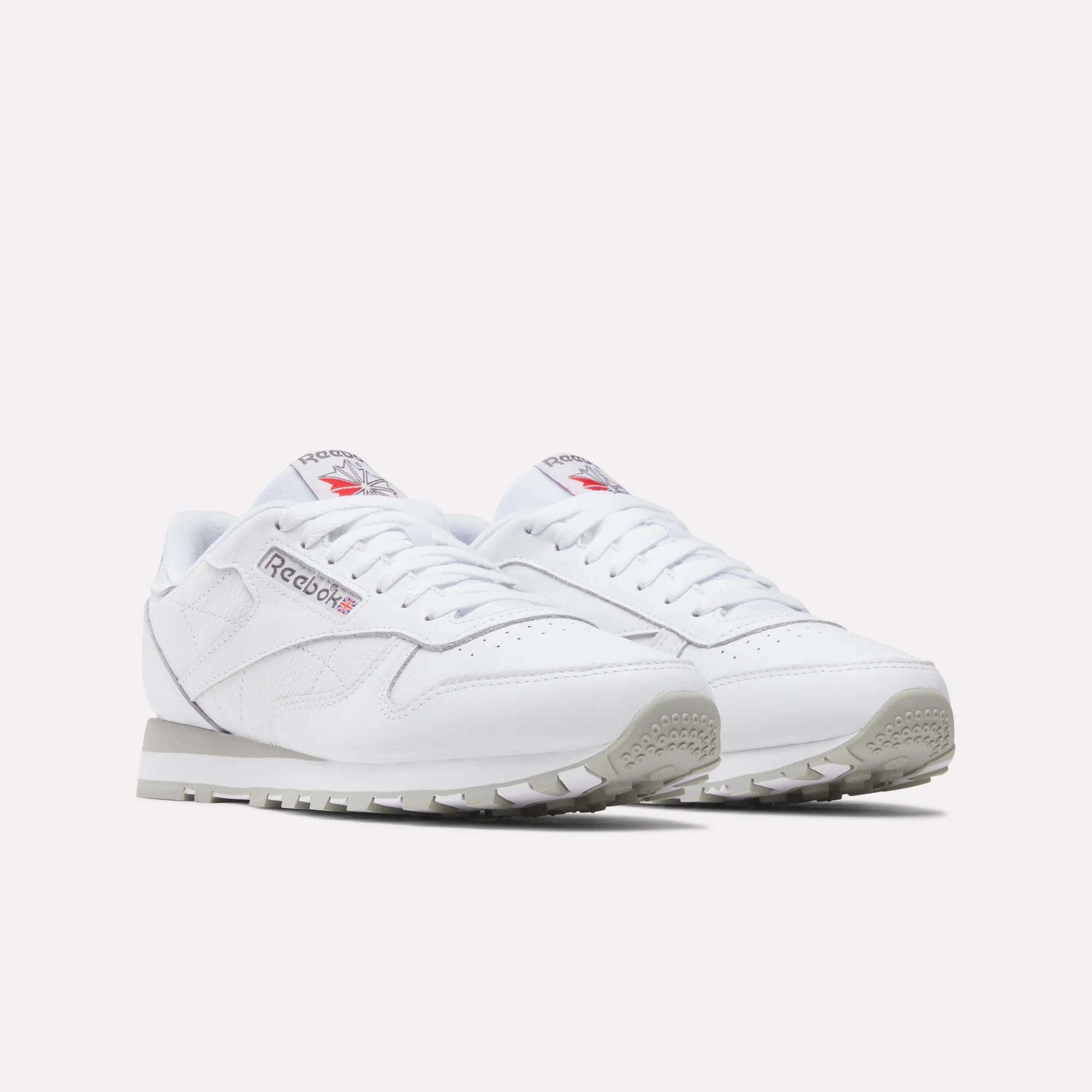 Reebok Classic Leather Shoes in white, featuring grey soles and the iconic Reebok logo with Union Jack on the side and tongue, are displayed on a plain white background for a timeless retro look.
