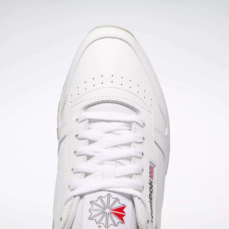 Top view of Reebok Classic Leather Shoes in white, retro style with durable leather, white laces, toe perforations, and the Reebok logo with British flag on the side and tongue against a light background.