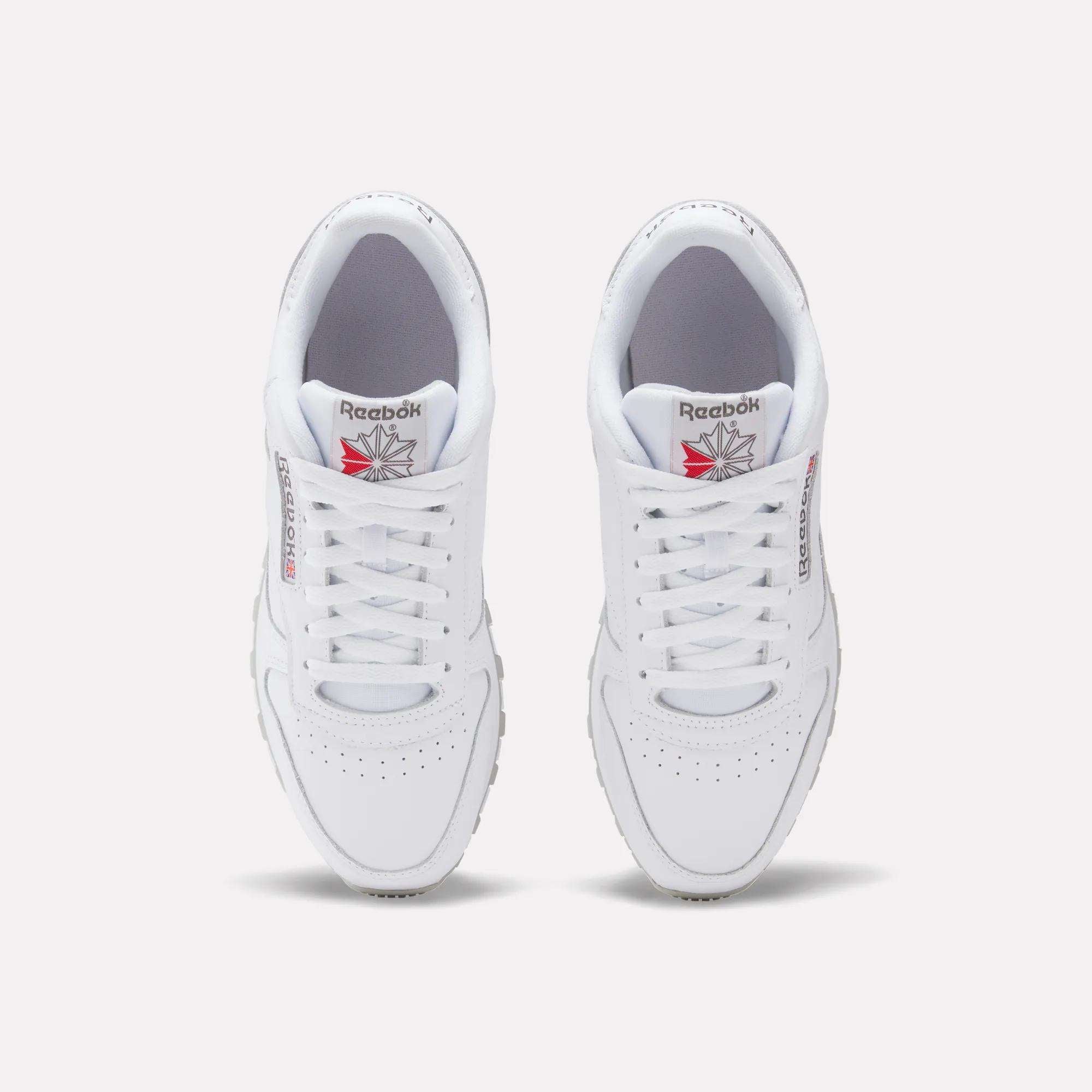 A top-down view of Reebok Classic Leather Shoes, featuring white uppers, laces, and the Reebok logo with red detailing on each tongue.