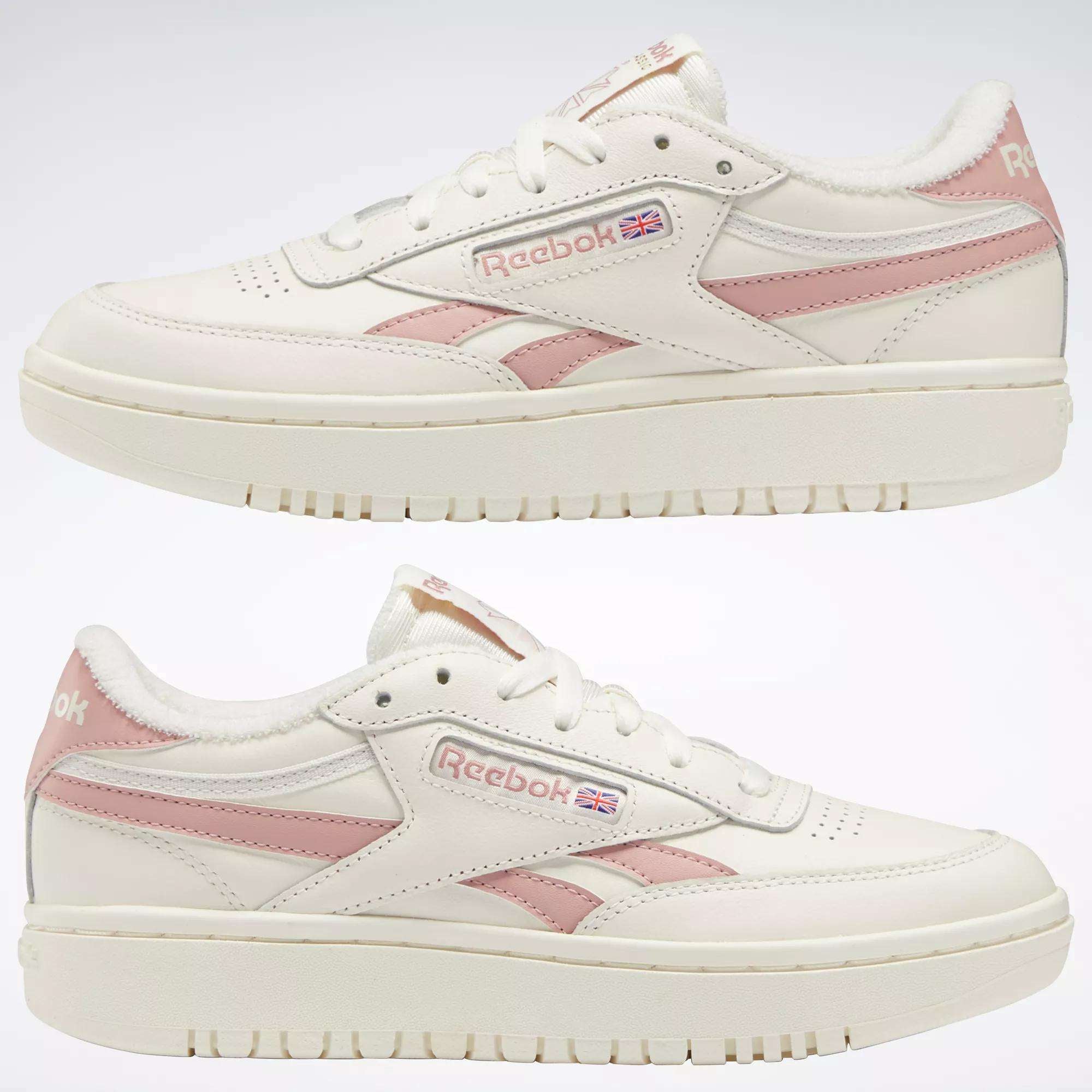 Two off-white Women's Club C Double Revenge Shoes by Reebok, featuring a leather upper and pink accents, are displayed side by side on a plain background, highlighting the court-inspired outer profile.