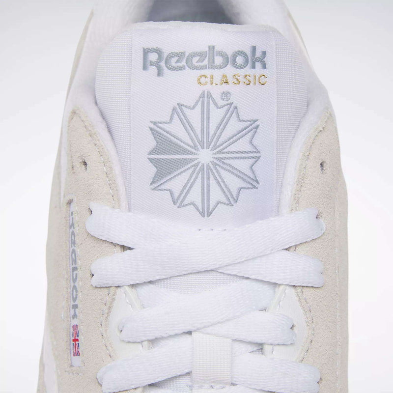 Close-up of the Women's Classic Nylon Shoes from Reebok, featuring the logo, starburst design, and CLASSIC text in gold on the tongue. White laces are neatly tied on this iconic everyday sneaker.