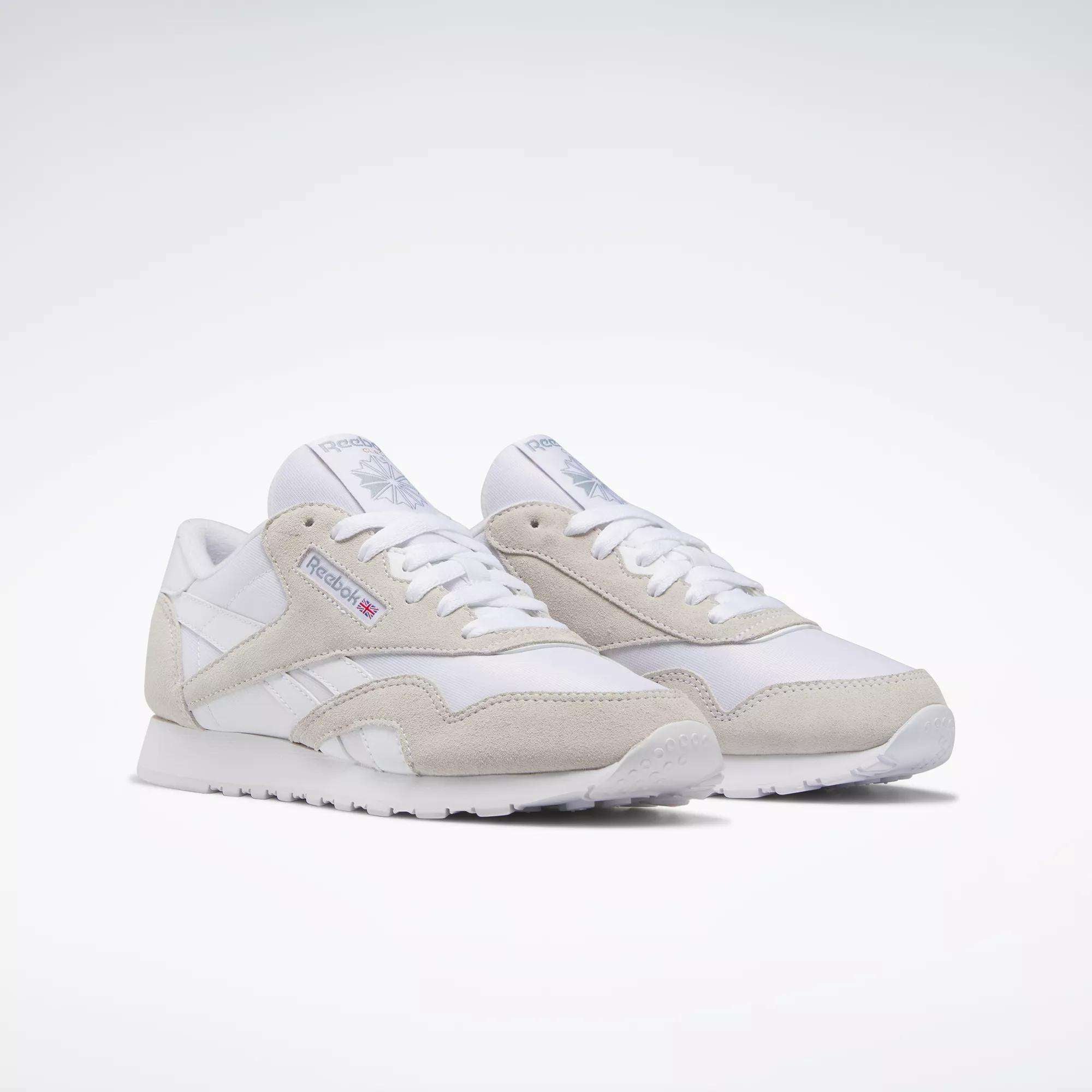 Reebok Women's Classic Nylon Shoes in white with gray suede accents, white laces, and the Reebok logo on the side—stylish everyday sneakers shown on a white background.