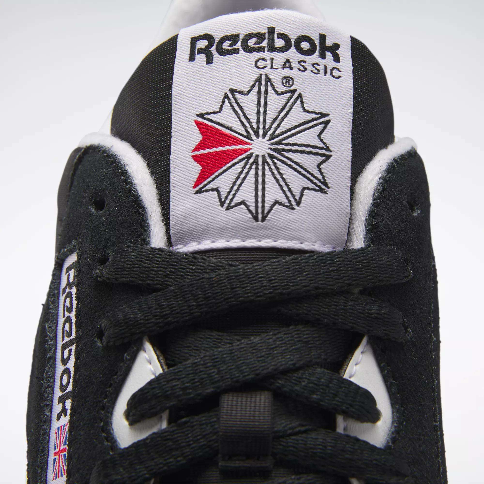 Close-up of Men's Classic Nylon Shoes by Reebok in black and white, featuring the Reebok logo on the tongue, black laces, and a UK flag patch—ideal everyday sneakers with timeless style.
