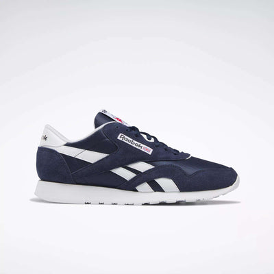 The Reebok Men's Classic Nylon Shoes feature a navy blue nylon upper with white accents and the signature Reebok logo. Shown in side profile on a plain white background, these are perfect classic everyday sneakers.