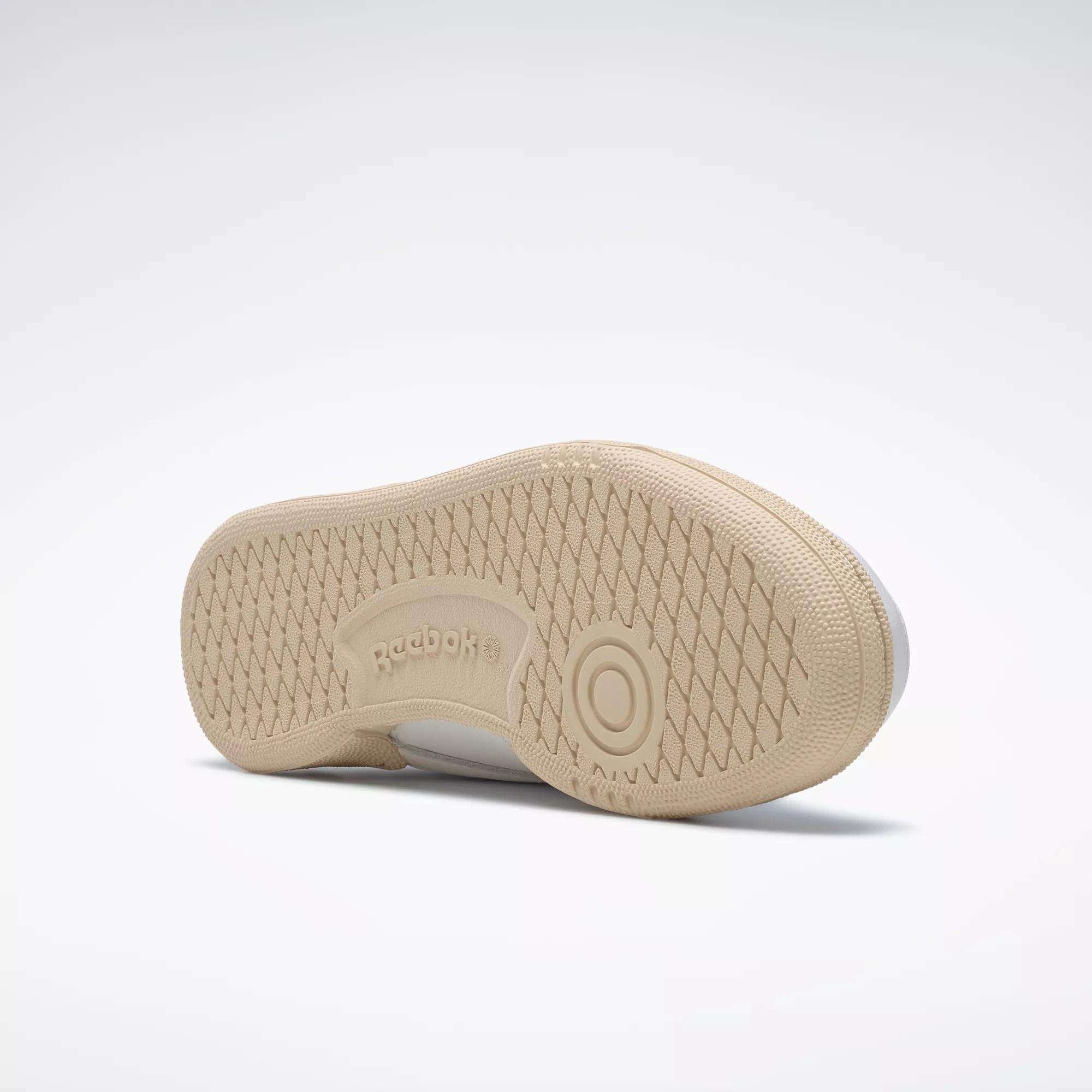 The Reebok Women's Club C 85 Vintage Shoes, shown in beige on a light background, feature a textured herringbone rubber outsole with circular treads and Reebok branding—making them an excellent choice in women's tennis footwear.
