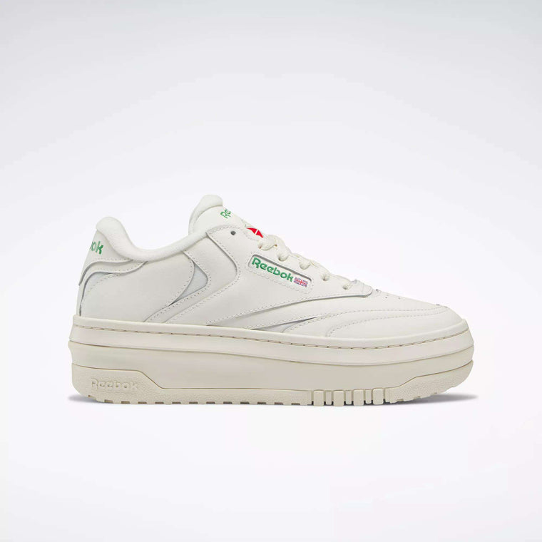 The Women's Club C Extra Shoes by Reebok feature a white design with a platform midsole, green branding, and a small Union Jack flag on the side—an elevated choice for women's footwear.