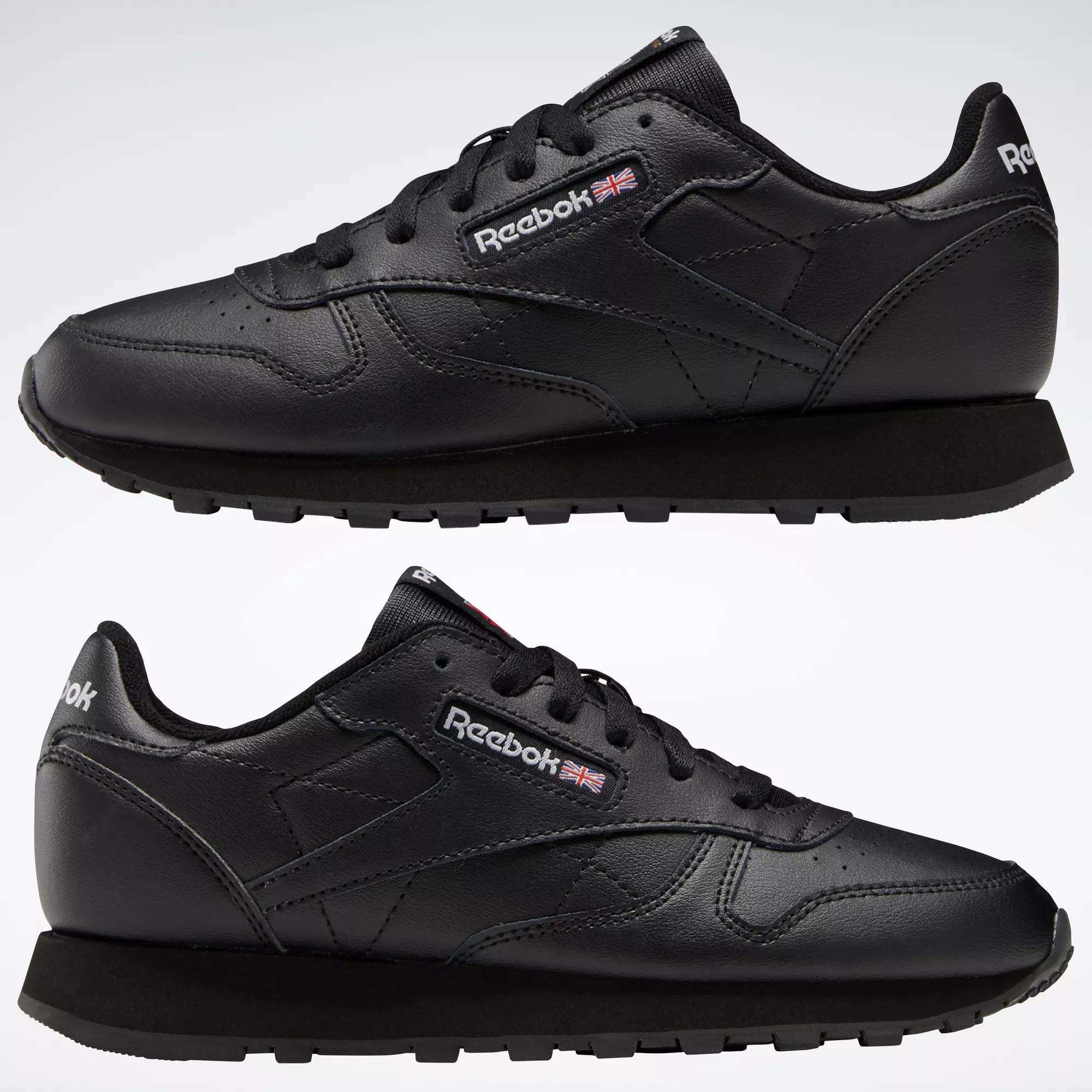 The Reebok Classic Leather Shoes - Big Kids are black sneakers with a classic design, black soles and laces, plus the Reebok logo and UK flag on the side and tongue.