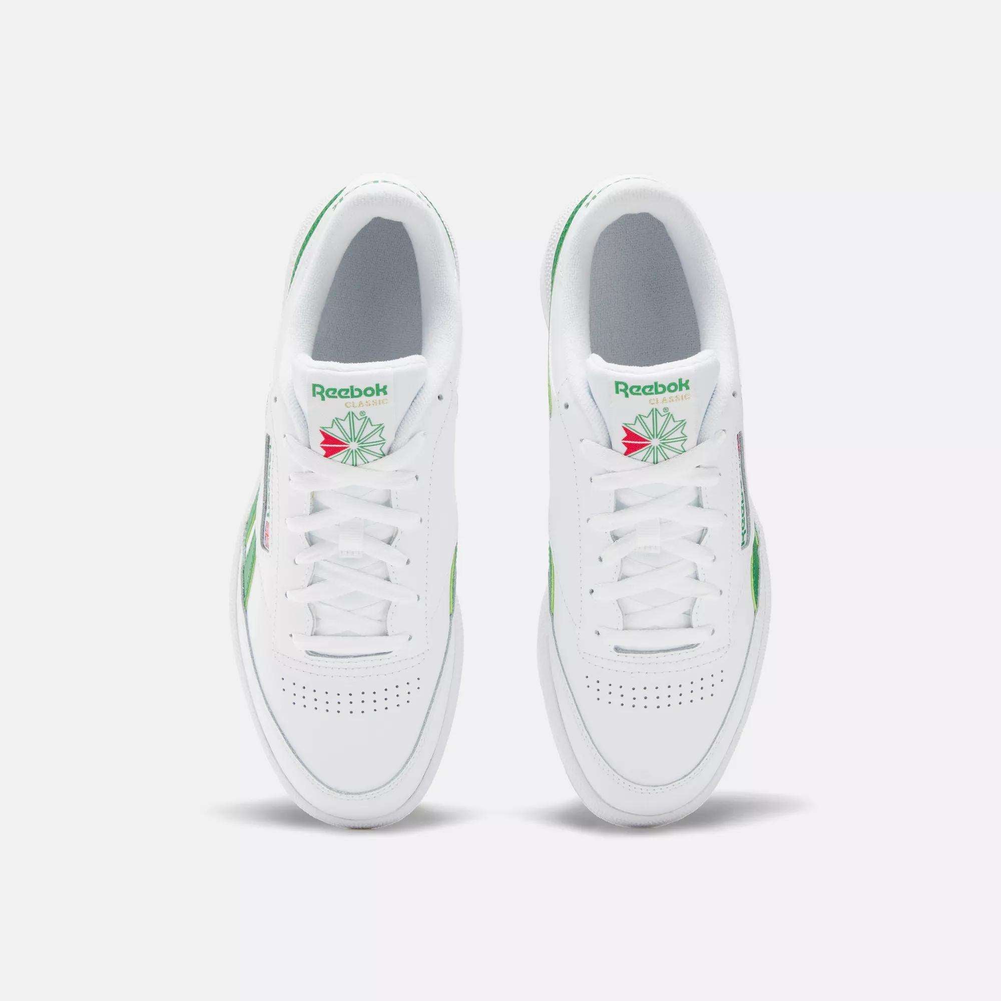 Top view of Reebok Club C Revenge Shoes in white with green and pink accents, laces, perforated toe boxes, and the classic Reebok logo with a green starburst on the tongue—ideal casual leather footwear.