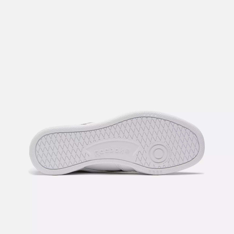The image shows the white rubber sole of Reebok Club C Revenge Shoes, viewed from below, displaying a herringbone tread pattern and the Reebok logo embossed at the center.