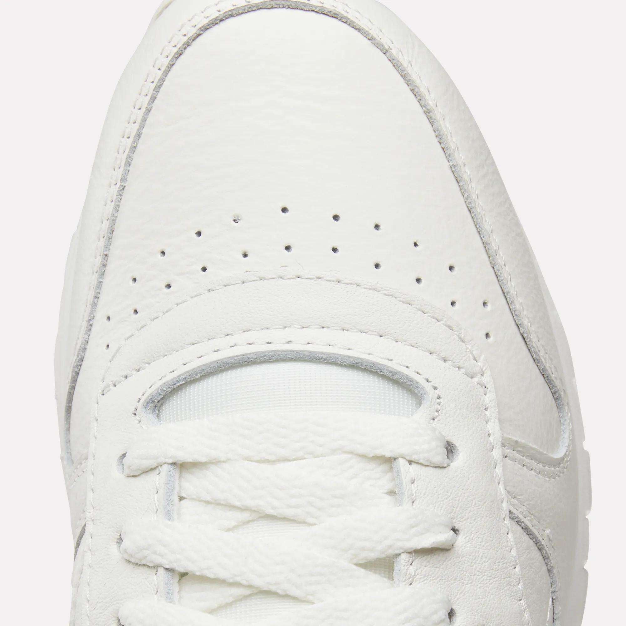Close-up of the toe area of Reebok Classic Leather Shoes, highlighting their retro style with white laces, a textured and durable leather upper, and small perforations for ventilation.
