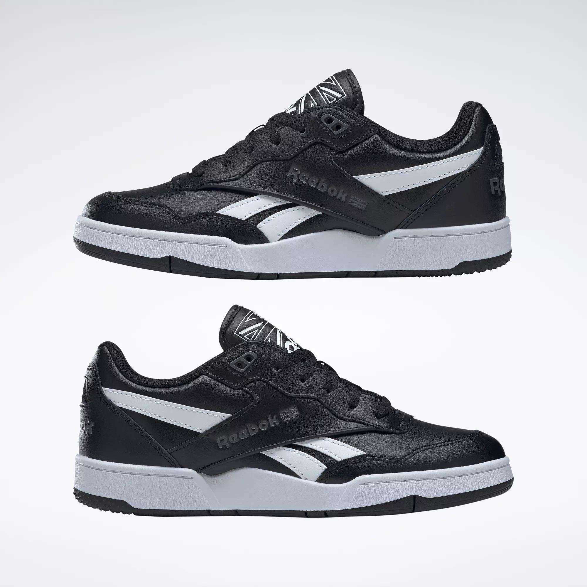 The Reebok BB 4000 II Shoes are black with white accents and grey soles, shown from the side against a plain light background. The Reebok logo appears on both the side and heel of each shoe.