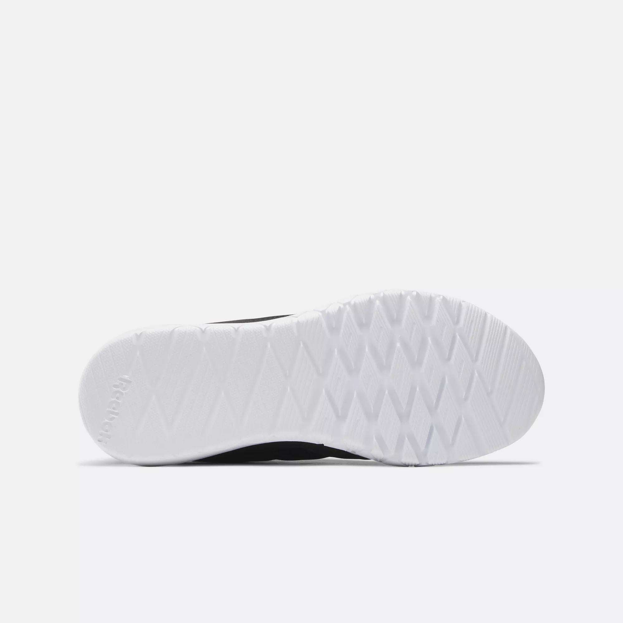 The image displays the bottom view of a Reebok Women's Flexagon Energy 4 Training Shoe, featuring a textured white rubber sole with a diamond pattern, set against a plain light gray background.