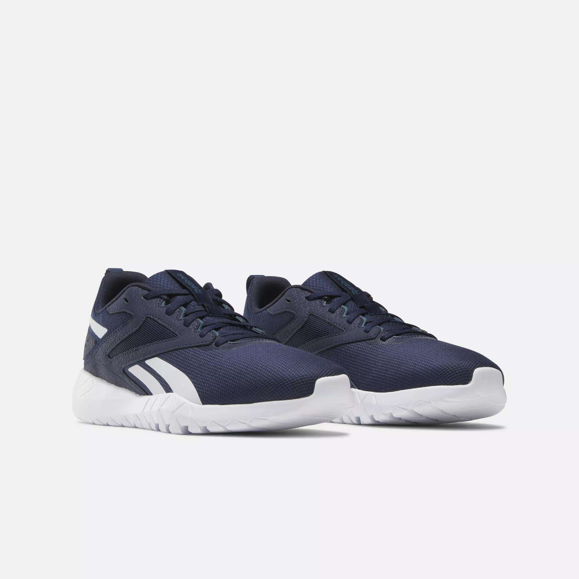 A pair of Reebok Men's Flexagon Energy 4 Training Shoes in navy blue with white soles and side stripes, made from breathable mesh, displayed on a light background showing both the outer and front sides.